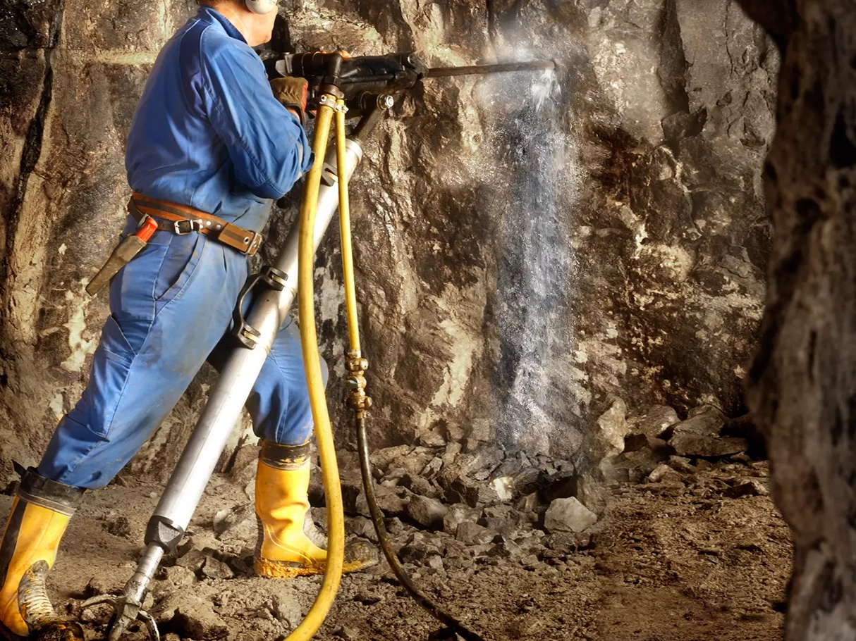 En operatör som bergborrar i vägg med en knämatare hyrd från Kendrill.